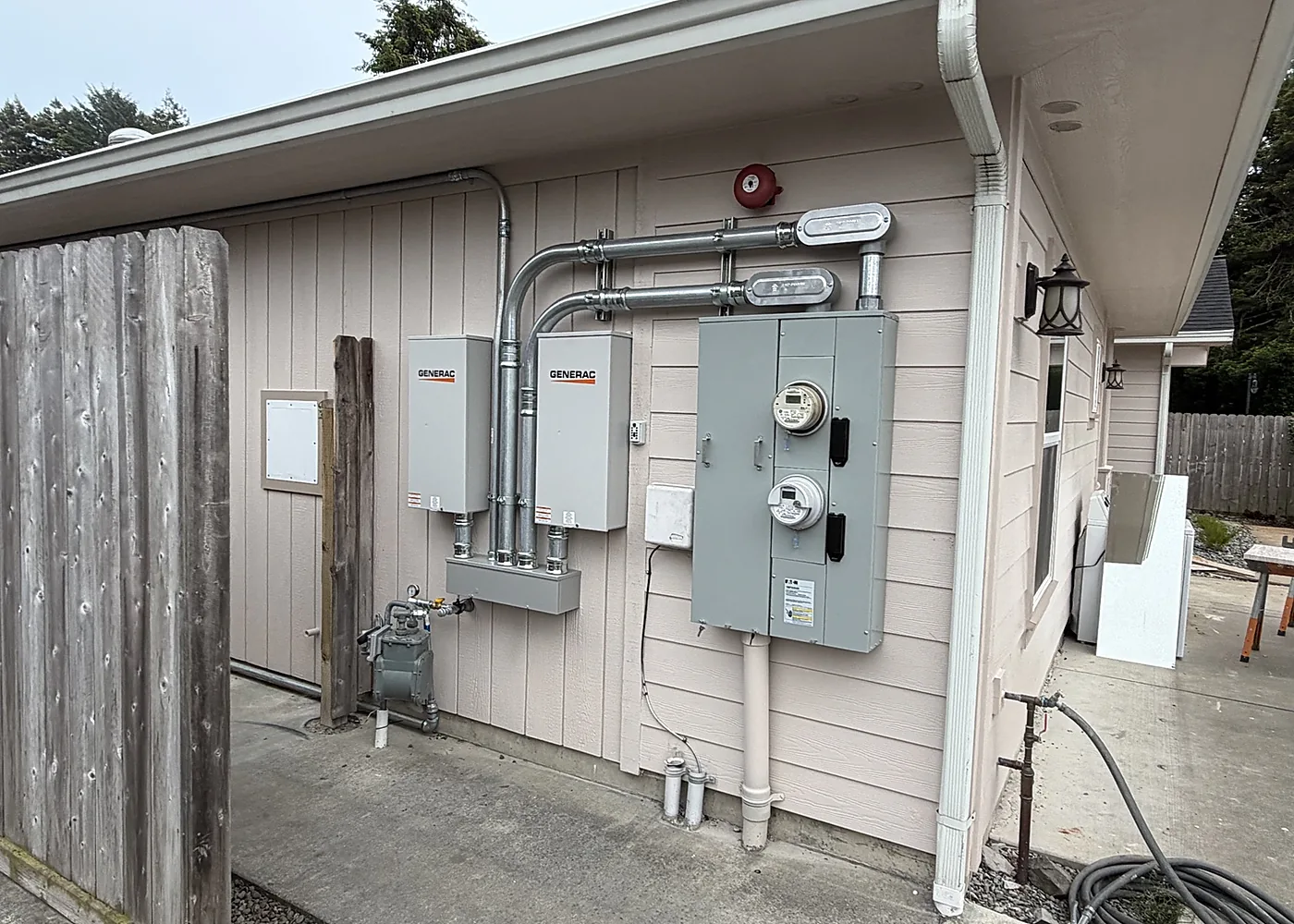 Two Generac automatic transfer switches installed beside a dual-meter service